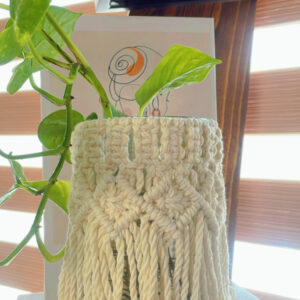 Florero de vidrio con faldilla de macramé.