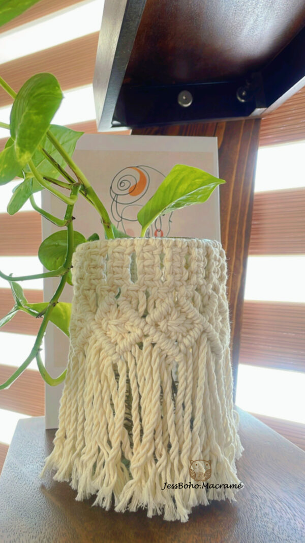 Florero de vidrio con faldilla de macramé.