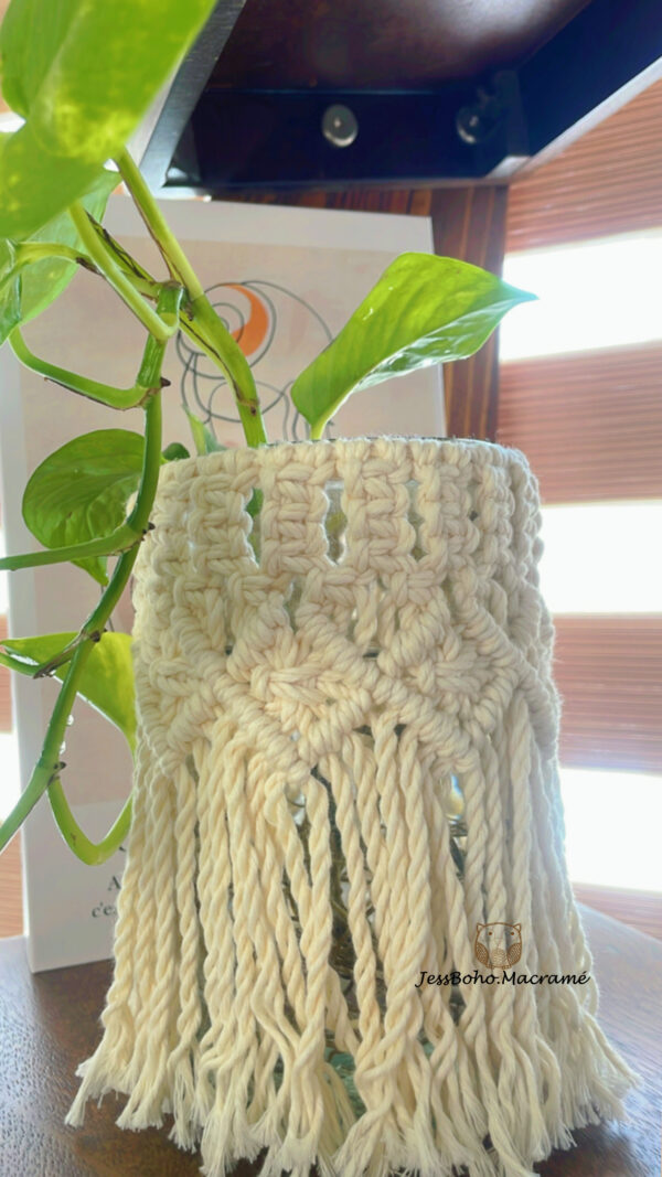 Florero de vidrio con faldilla de macramé.